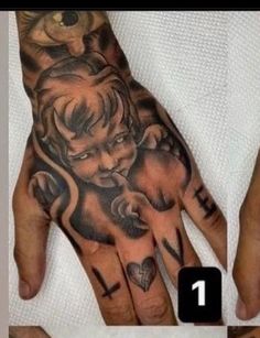 a man's hand with an angel and cross tattoo on the middle of it