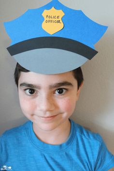 a young boy wearing a paper police hat