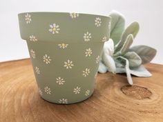 a green flower pot sitting on top of a wooden table