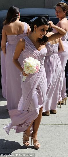 the bridesmaids are walking down the street together