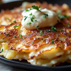 a close up of a plate of food with potatoes and cream on top, garnished with parsley