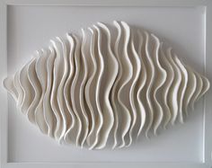 a white wall sculpture with wavy lines on it