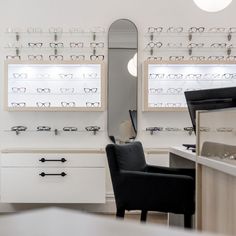 a pair of glasses sitting on top of a counter next to a chair in front of a mirror