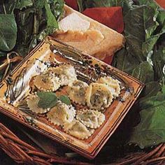 some food is sitting in a wicker basket on a table with bread and greens