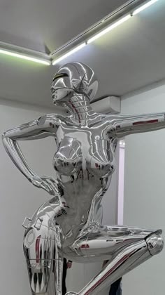 a silver statue is standing in the middle of a room