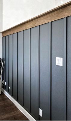 an empty room with black paneling and white walls