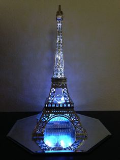 the eiffel tower is lit up with blue lights on it's sides