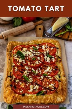 a tomato tart with cheese and basil on top is shown in the foreground