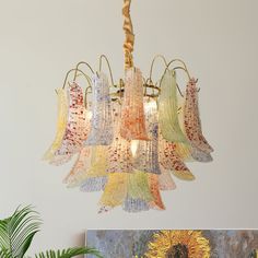 a chandelier hanging from a ceiling in a room with paintings on the wall