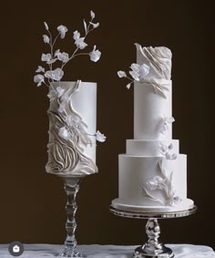 two white wedding cakes sitting on top of a table