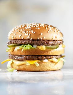 a hamburger with cheese, lettuce and pickles