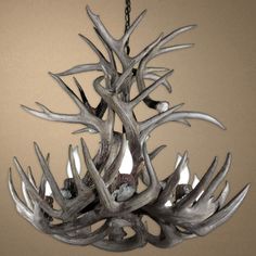 a chandelier made out of antlers hanging from a chain