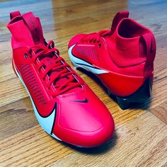 a pair of red and white shoes sitting on top of a wooden floor