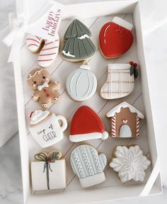 decorated cookies in a white box on a table