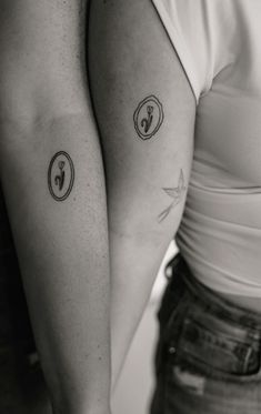 two people with matching tattoos on their arms