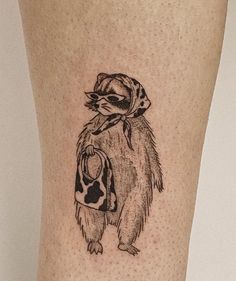 a tattoo on the leg of a person with a hat and scarf around his neck