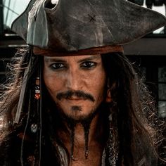 a close up of a person wearing a pirate hat with long hair and piercings