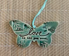 a ceramic butterfly ornament that says love is all you need