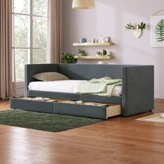 a day bed with drawers underneath it in a living room next to a large window