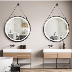 two round mirrors hanging on the wall above sinks