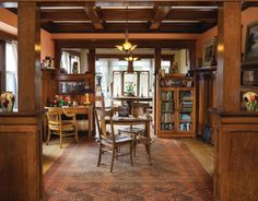 the dining room is decorated in wood and has many bookshelves