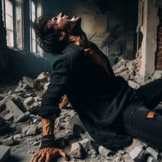 a man sitting on the ground with his mouth open and hands in the air, surrounded by rubble