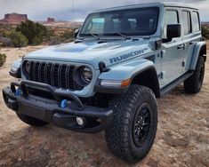 a blue jeep is parked in the desert