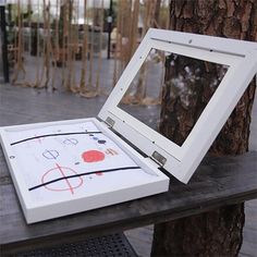 an open box sitting on top of a wooden table next to a tree and fence