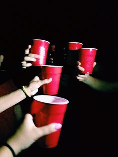 four people holding red cups with the words i'm not as think as you drunk i am