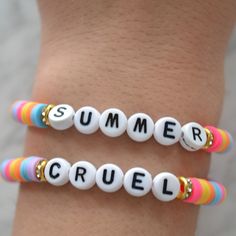 two bracelets that say summer and cruel on the wrist, with beads attached to them