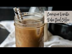 a mason jar filled with iced coffee on top of a table