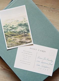 an old postcard sits on top of a green envelope