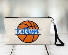 "Personalized Basketball Zippered Pouch. Personalized with team colors and name.  Be sure to include all personalization info when checking out.  Please list 2 team colors and player name(s) in the personalization box when checking out.  We will send a proof for any team orders over 12 or anytime we may have a question about personalization info.  Please check Etsy messages for your proof.   These linen zippered pouches are the perfect gift for sports teams!  Can be used for accessories, makeup, phones, tech accessories and more.  Perfectly sized to fit in sports bag, travel bag, or backpack.  Measures 9.25\" x 6.5\".  Black wrist strap attached with a lobster clasp.   If you don't see a sport or design you need please message us and we can help!  20% discount for team orders of 12 or more Personalized Sports Gifts, Basketball Team Gifts, Zippered Pouches, Personalized Basketball, Team Bags, Personalized Pencils, Senior Gifts, Senior Night, Basketball Team