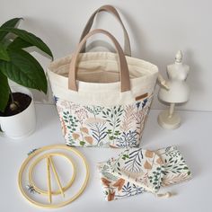 a tote bag sitting on top of a table next to some scissors and other items