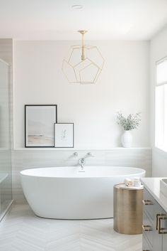 a bathroom with a large white bathtub next to a sink and mirror on the wall