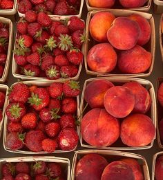 several baskets filled with different types of fruit including peaches and strawberries in them