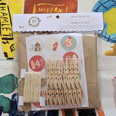 several wooden clothes pins in a package on top of a table with other items around it