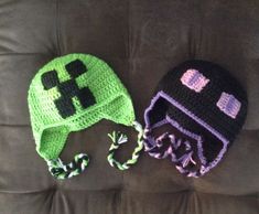 two crocheted hats sitting on top of a couch