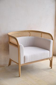 a white chair sitting on top of a tile floor next to a wall and window