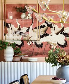 there are many birds on the wall in this dining room that is decorated with pink and gold