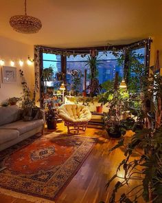 a living room filled with furniture and lots of plants on the windows sills