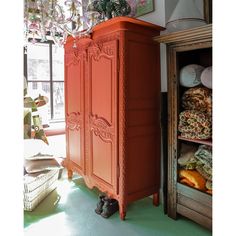 an orange armoire sitting in front of a window