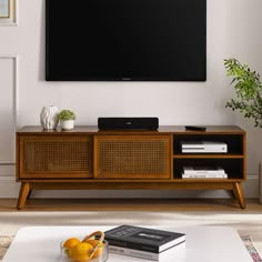 a flat screen tv mounted to the side of a wooden entertainment center in a living room