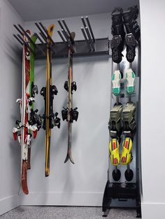 there is a rack with skis and snowboards in the corner next to each other