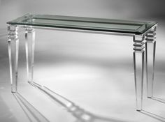 a glass and metal console table with three legs on the bottom, in front of a white background