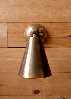 a metal bell mounted on the side of a wooden wall