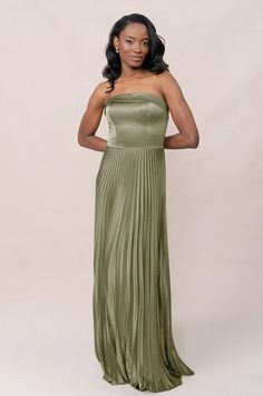 a woman in a green dress posing for the camera with her hands on her hips