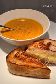 a bowl of soup and grilled cheese sandwich on a plate