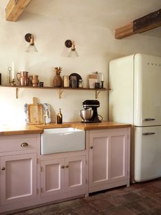 a white refrigerator freezer sitting inside of a kitchen next to a wooden counter top