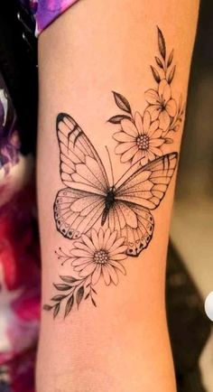 a butterfly and flowers tattoo on the arm